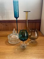 Wide shot of all five glass pieces showing variety of shapes and colors.