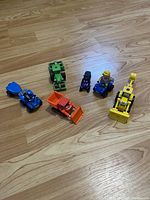 All six Bob the Builder vehicles arranged on wood floor showing full lot contents and character variety.