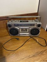Front view of vintage Sanyo stereo cassette player with speakers, cassette deck, and control buttons.