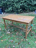 Full view of the oak table outside showing the rectangular top and legs.