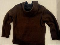 Front view of the chocolate brown wool sweater jacket laid flat, showing full length sleeves and high neck design.