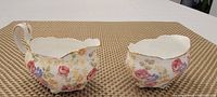 Creamer and open sugar bowl showing floral pattern and gold trim on a table