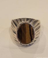 Front view showing oval tiger eye stone set in textured sterling silver band