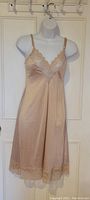 Vintage beige Lily of France nylon slip with lace bust detail on mannequin