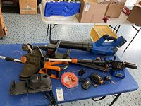 Overview photo showing Kobalt blower and Worx weedeater with accessories on a blue table