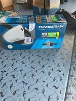 Image showing Chamberlain garage door opener in original box with product details and branding visible.
