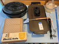 Photo showing all items including the Presto electric griddle, Hamilton Beach electric knife in box, Black & Decker Handy Juicer, 16 oval roasting pan with lid, various kitchen tools including thermo fork, Bar-B Check, microwave bacon tray, spatula.