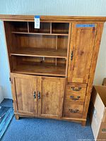 Full view of the wood storage cabinet showing shelves, drawers, and doors.