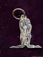 Close-up view of the yellow gold pendant featuring two birds side by side on a branch with gold ring bail.