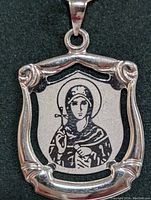 Front view of 10K gold religious pendant showing detailed engraving and ornate frame.