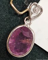Close-up on the pink sapphire oval gemstone in bezel setting.