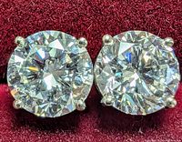 Front view of both round diamonds in prong settings on red background