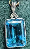 Front view of rectangular emerald-cut blue topaz bezel set in 14K gold