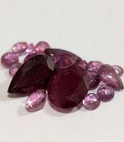Close-up of assorted ruby gemstones showing various cuts and colors.
