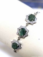 Close-up side view of the bracelet showcasing three emerald stones with CZ accents in star-shaped silver settings.