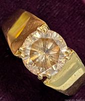 Close-up photo of silver ring with round moissanite stone showing ring band and stone setting