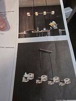 Photo of product brochure showing installation and depiction of kitchen island light fixture with six square crystal lampshades in linear design.