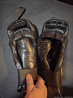 Two black sparring gloves side by side showing overall appearance, elastic wrist closures, and glossy synthetic leather.