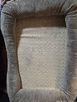 Top view of the XL rectangular pet bed showing soft beige plush fabric interior and cushioned walls.