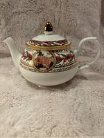 Front view of the teapot showing decorative design with image of the Empress building and gold accent handle.