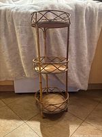 Full view of the three-tier rattan plant stand showing structure and three round shelves with lattice design.