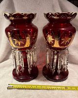 Pair of ruby glass Victorian lustres displayed side-by-side with a tape measure showing 14 inches height.