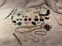 Full view of vintage jewelry assorted items including earrings, necklaces, bracelets, pendants.