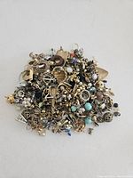 Pile of assorted 1970s vintage pierced earrings in gold and silver tones with various designs including small hoops and posts