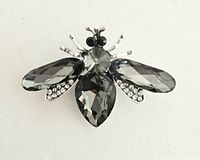 Close-up of the bee brooch showing black and clear rhinestones with silver-tone detailing