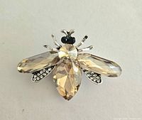 Close-up clear view of the gold-tone rhinestone bee brooch highlighting its faceted stones and metal detailing.