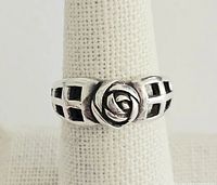 Front view of the sterling silver rose ring with open lattice band design on ring display stand.