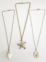 Three vintage necklaces displayed side by side on white background, showing pendants and chain styles