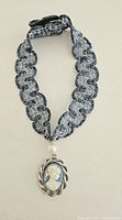Full view of blue mesh lace choker band with cameo pendant attached.