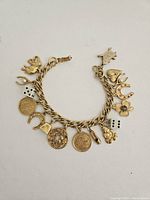 Full view of the vintage gold charm bracelet with all attached charms laid flat