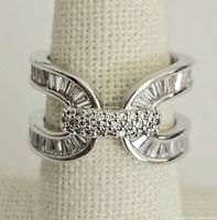 Front view of vintage silver-tone ring showing central cluster of round rhinestones and baguette-cut rhinestones along curved bands.