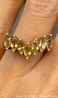 Close-up photo of the sterling silver ring with seven marquise-shaped citrine stones in a chevron arrangement worn on finger showing color and setting.