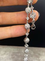 Close-up of sterling silver bracelet showing alternating round clusters and single clear stones with lobster claw clasp.