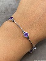 Bracelet worn on wrist showcasing the amethyst stones and sterling silver bars.