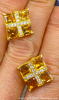 Front view of the pair of square earrings displaying four rectangular genuine citrine stones each, with clear stones arranged in a cross pattern on top, set in gold gilt overlay.