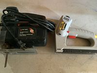 Black & Decker two speed scroller jig saw with blade and cord visible beside Stanley stapler