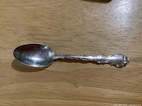 Photo of the full teaspoon showing the bowl and partial handle, placed on a wooden surface.
