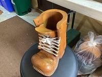 Front view of the carved wooden boot showing detailed lacing and toe design.
