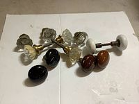 All twelve vintage door knobs arranged on white background, showing variety in material and design.