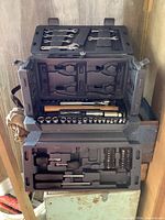 Open tool box revealing multiple trays and compartments loaded with assorted hand tools
