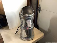 Full view of vintage Sunkist commercial juicer showing metal body, juicing cone, and spout for dispensing juice.