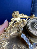 Close-up of the raised female figural handle and scrollwork on tray