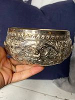 Side view showing intricate engraved floral patterns on the silver bowl