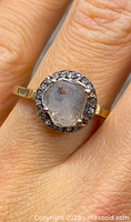 Top view of ring on model’s finger showing center and halo stones