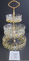 Full view of 3-tier bubble glass etagere showing clear and gold bubble accents. Middle tier at 7.25", top at 5", bottom tier 9" diameter. Gold-colored metal central rod and decorative handle visible.
