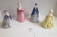 Overview photo showing the four lady figurines on display in pastel and soft colors, including Lladro, Coalport, and Royal Worcester pieces.